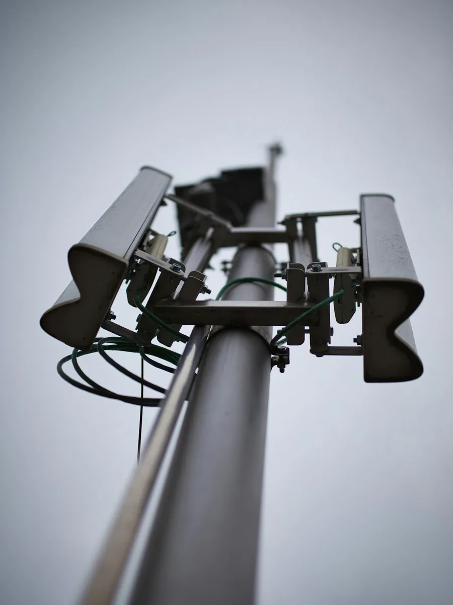 A field technician working on a pole